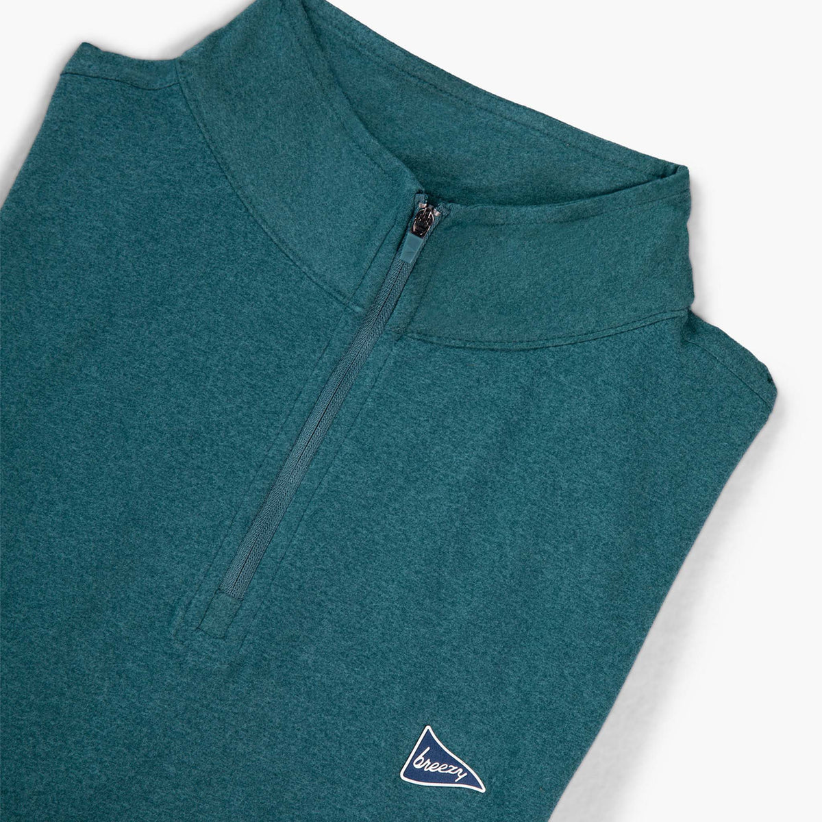 Angled view of Breezy forest green quarter-zip showing zipper detail and embroidered pennant logo on the chest.