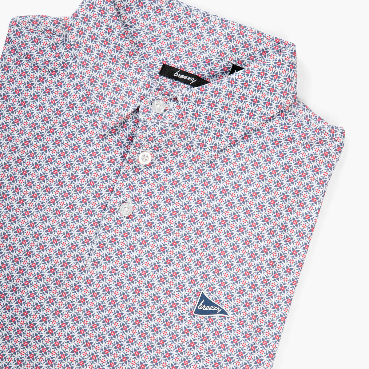 Angled view of Breezy RWB patterned polo shirt highlighting collar, button placket, and Breezy pennant chest logo.