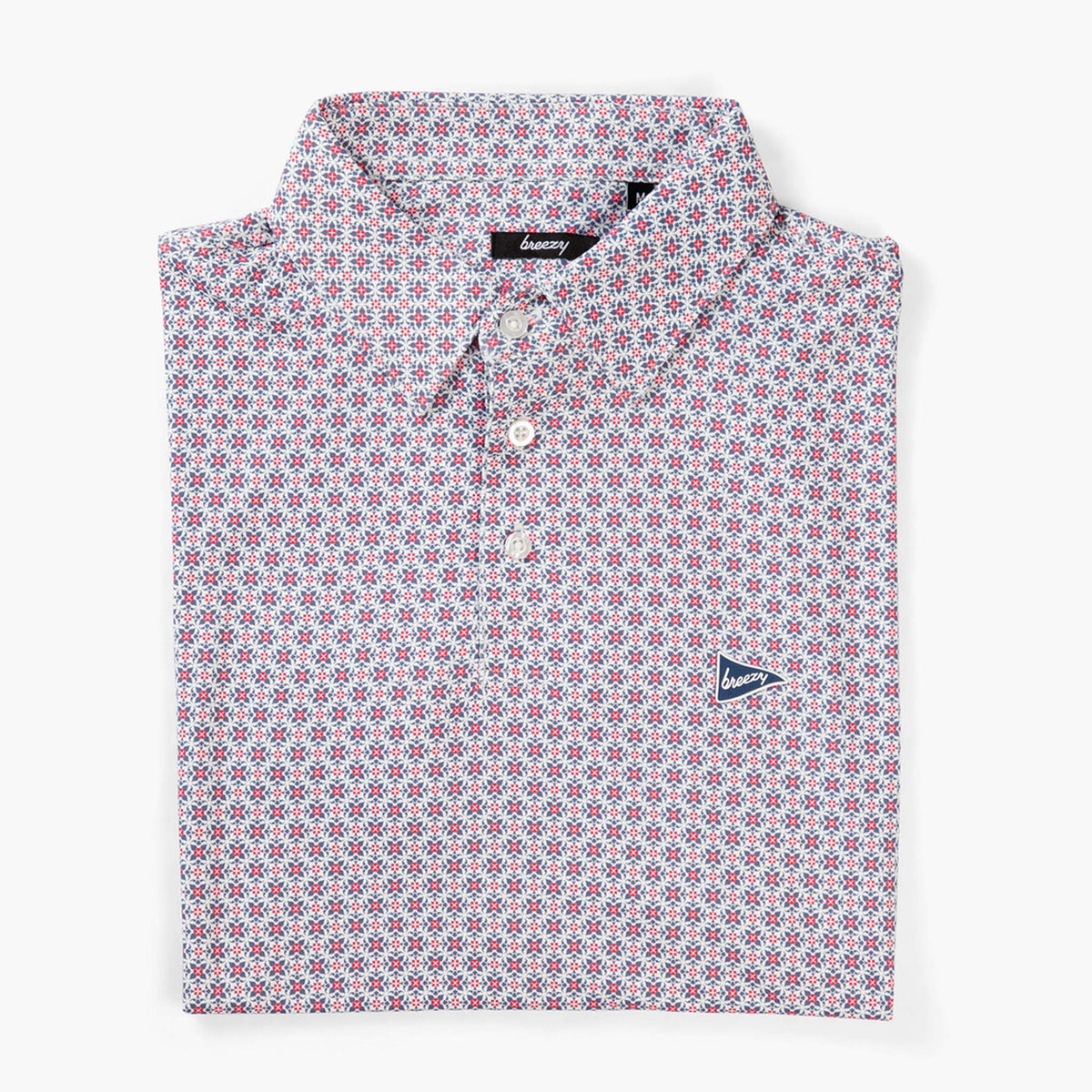Breezy RWB patterned polo shirt folded flat with button placket and allover red, white, and blue geometric design.