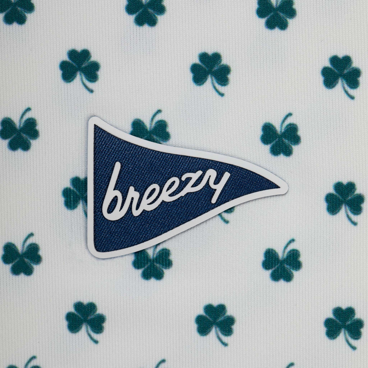 Patch with 'breezy' text on a white background with green clover patterns