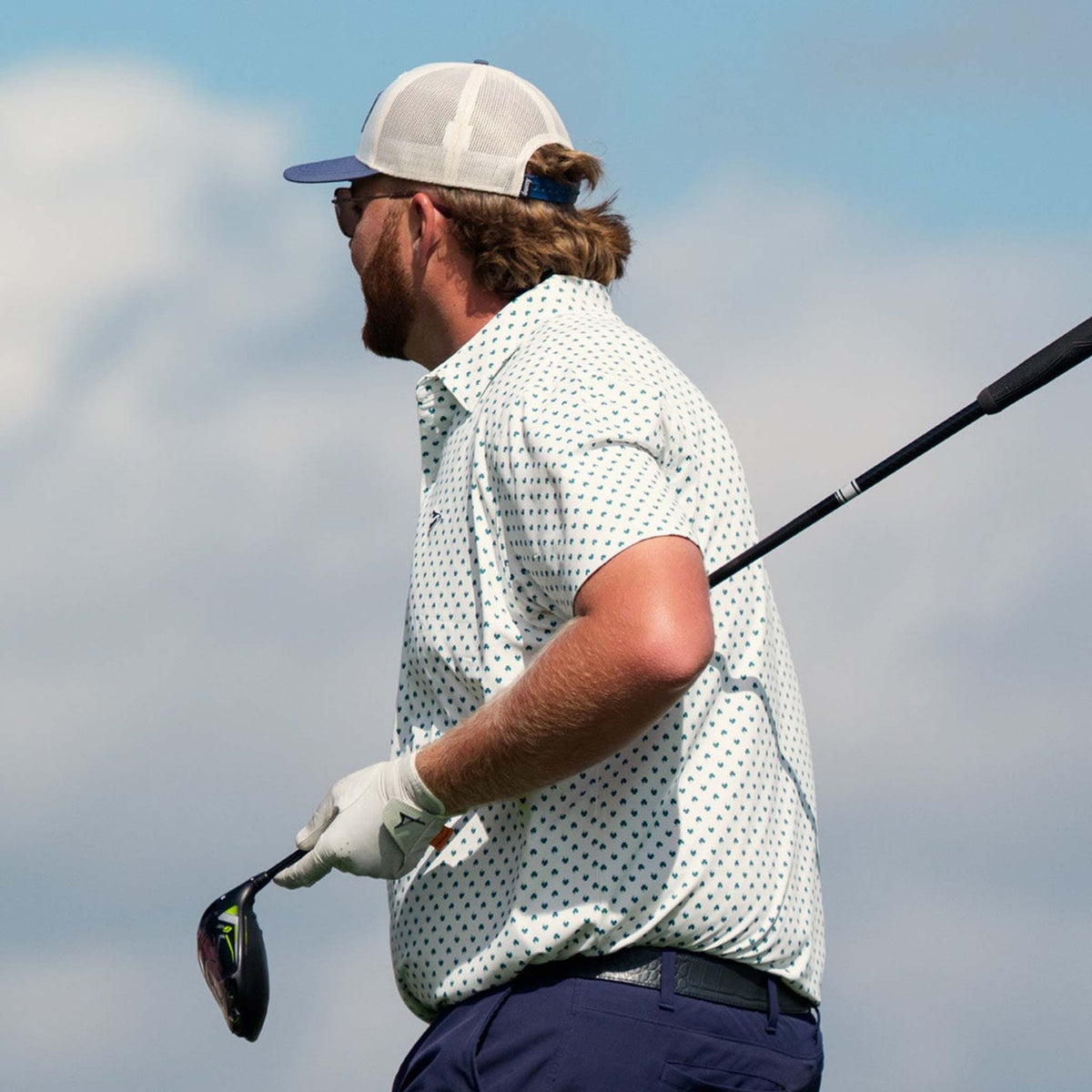 Man playing golf with a blurred sky background