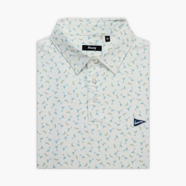 Folded men's white polo with an all over print of small martini glasses in blue and green shown on a white background