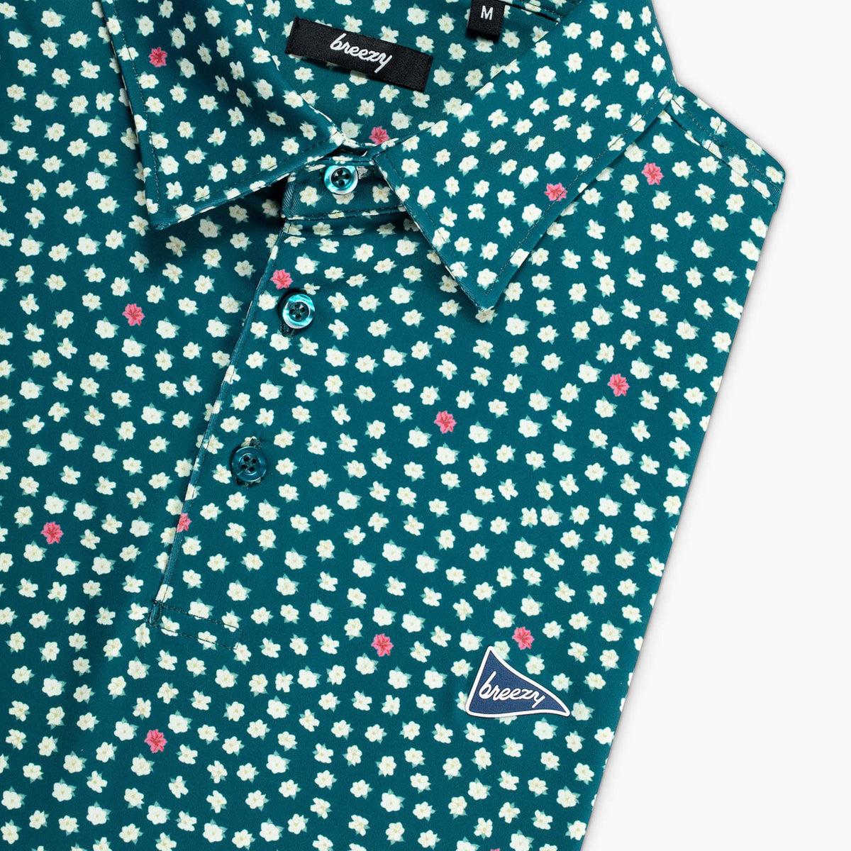 green shirt with small white floral pattern and 'breezy' branding on a white background