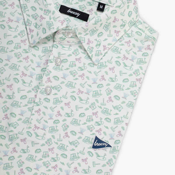 Shirt with a pattern of small golf themed illustrations on a white background, featuring the brand 'breezy'.