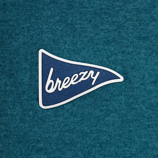 Embroidered patch with 'breezy' text on a blue fabric background