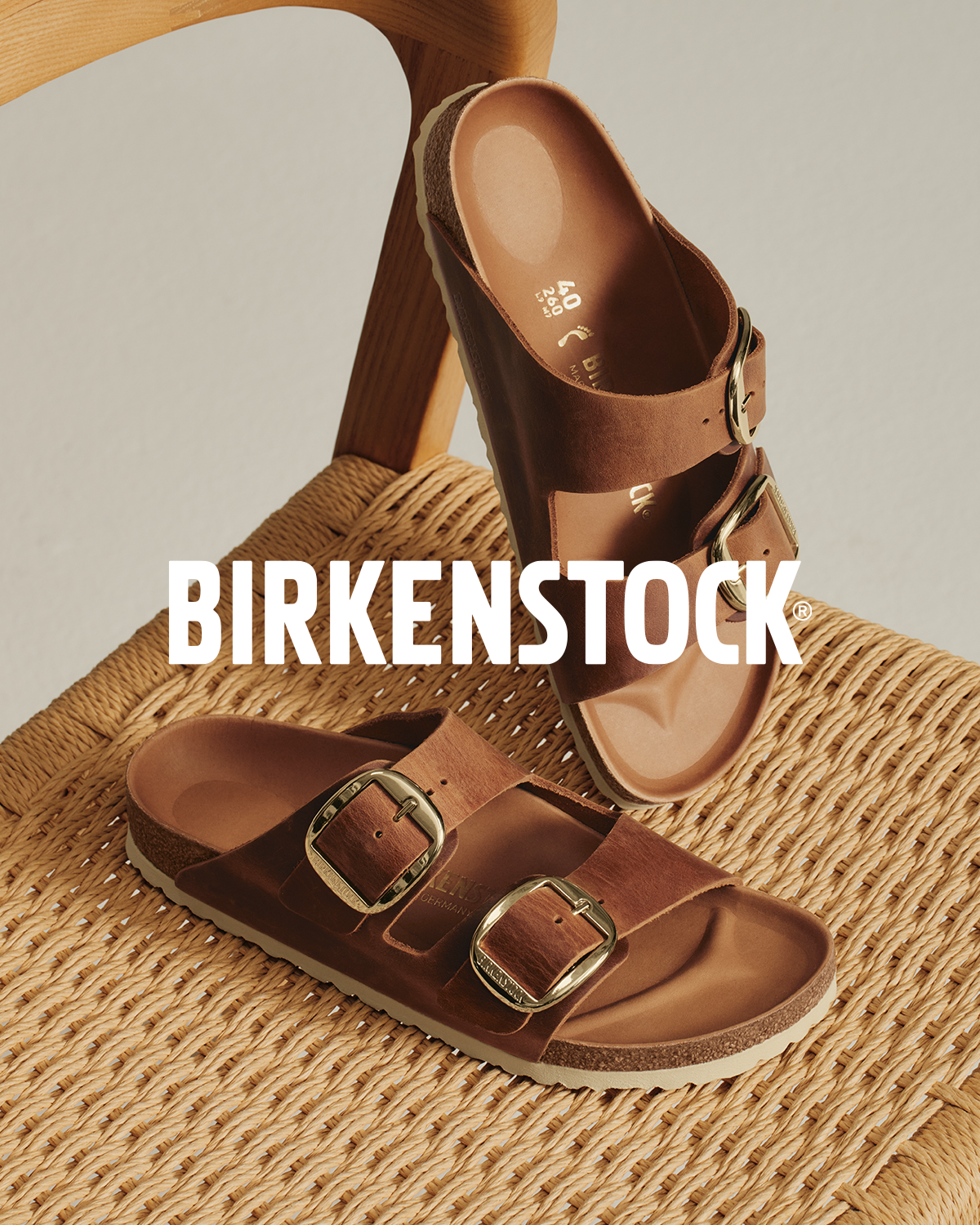 Pair of Birkenstock sandals sitting in a woven chair.