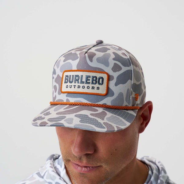 Man wearing camouflage cap with 'Burlebo Outdoors' logo shown on a plain background