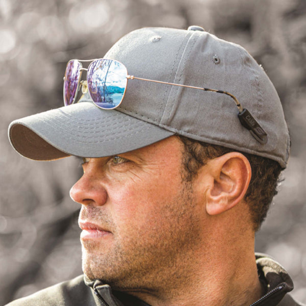 Man wearing a hat with the Cablz Shade Savers Magnetic Hatband System.  He is looking to the side, showing his sunglass with the magnetized silicone tips holding his glasses safely on his hat.