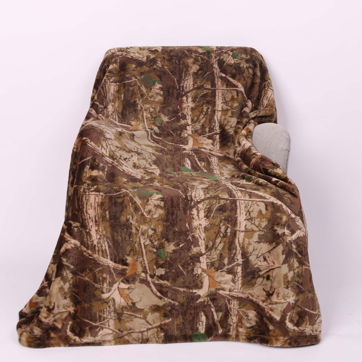 Camouflage-patterned blanket draped over a chair on a white background