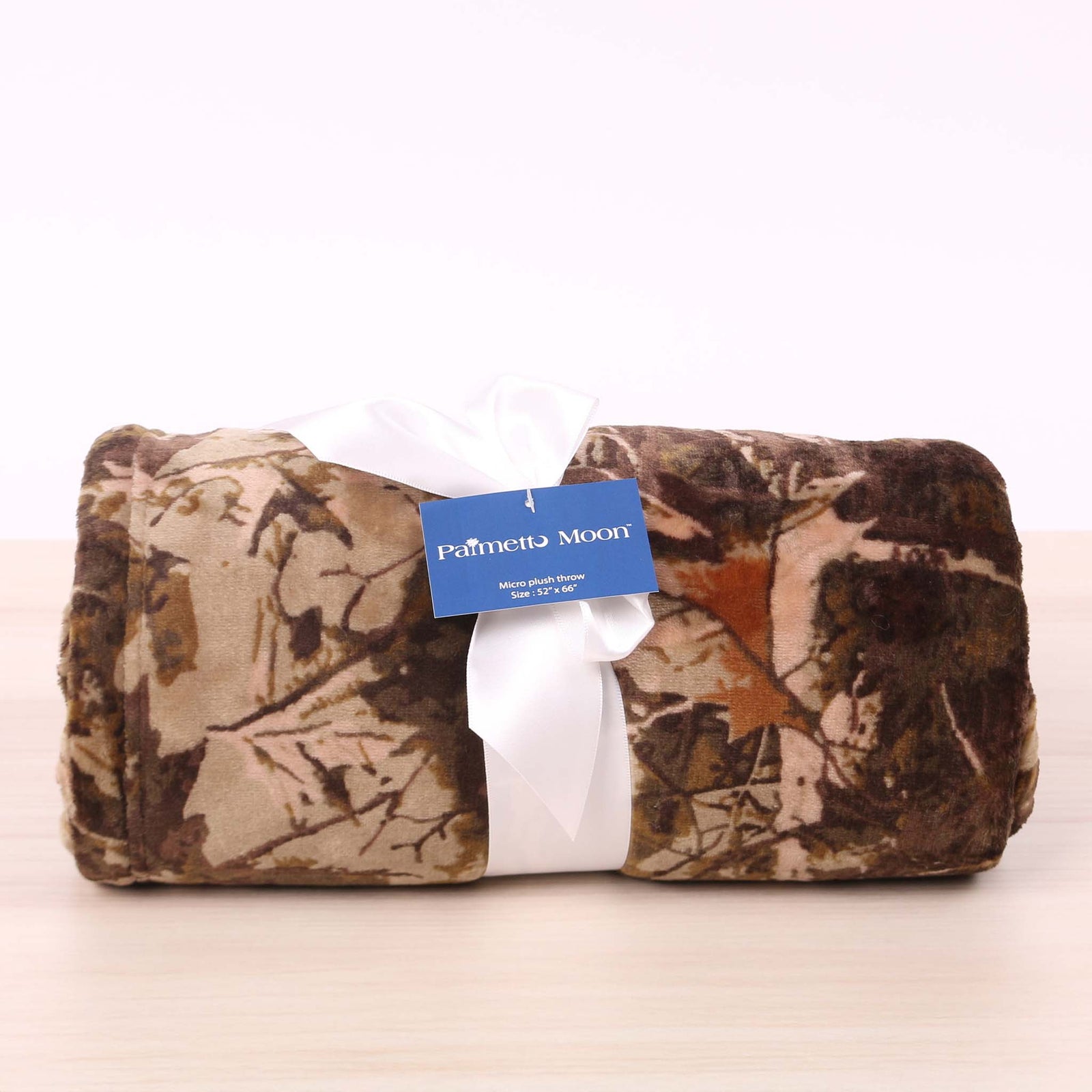 Cozy camo patterned fleece blanket rolled up and tied with a bow.