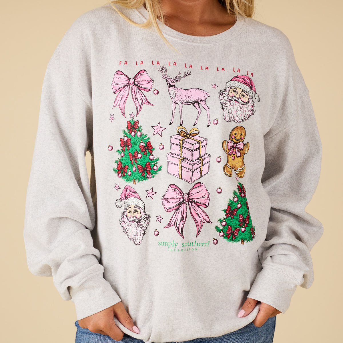 Close-up of Simply Southern Christmas Grid Sweatshirt showing pink bows, Santa faces, reindeer, Christmas trees, gifts, and gingerbread design.