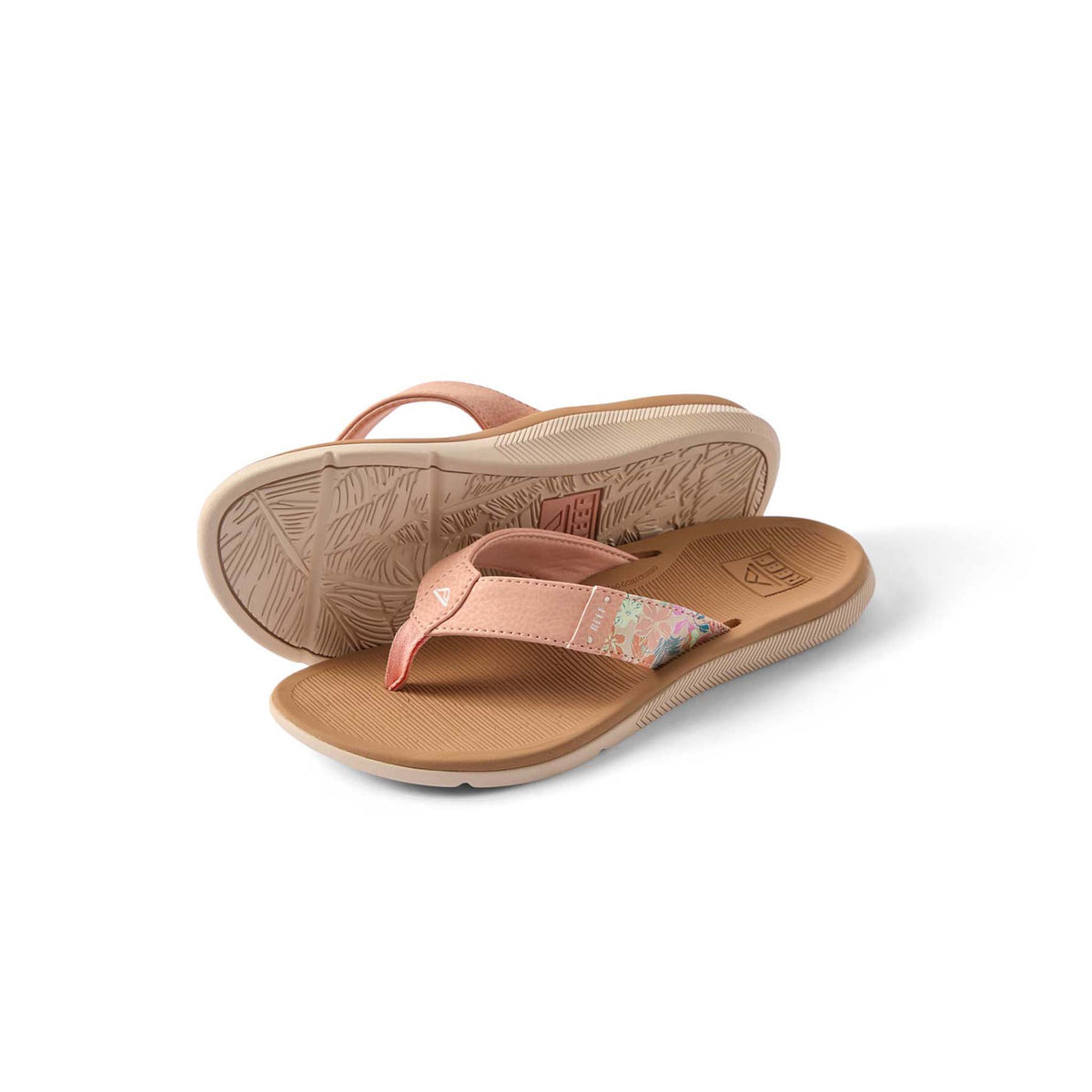 Pair of tan sandals with pink straps on a white background