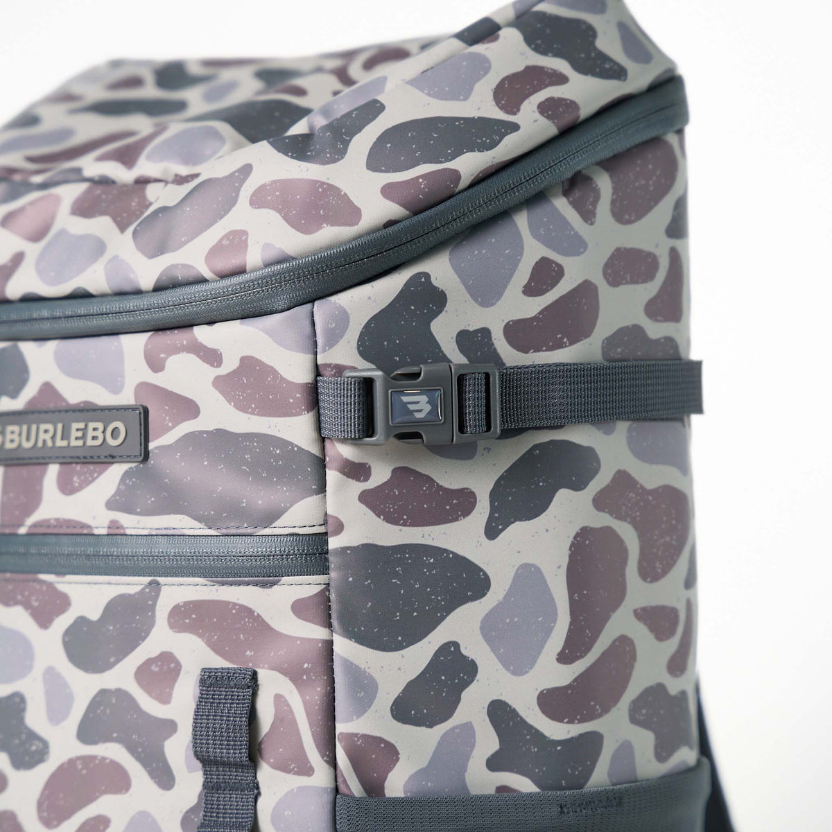 Burlebo Classic Deer Camo Cooler Backpack side detail showing compression strap buckle and camo fabric texture.