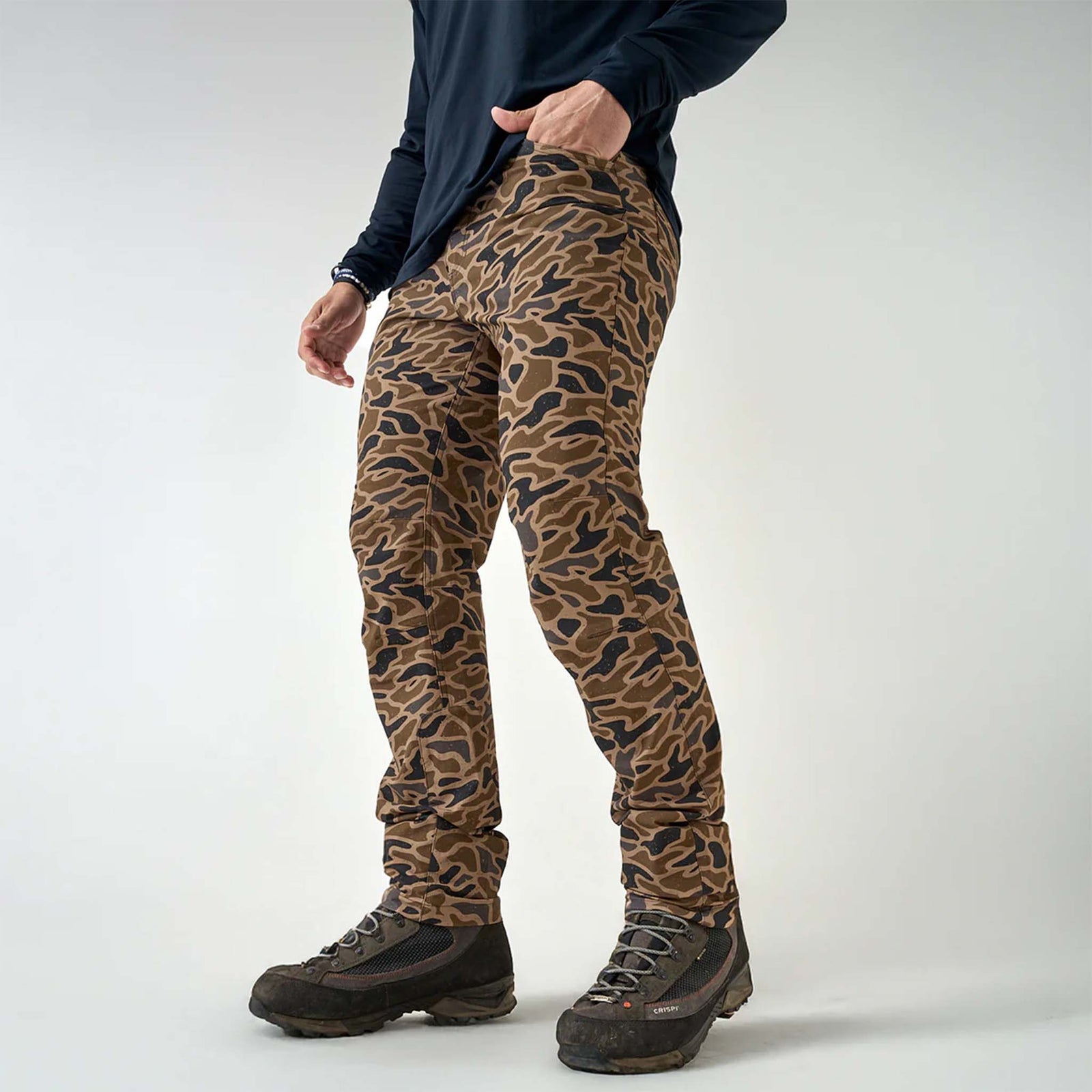 Burlebo Challenger Pants in gauge camo shown full length with hiking boots, styled with an black long sleeve shirt.
