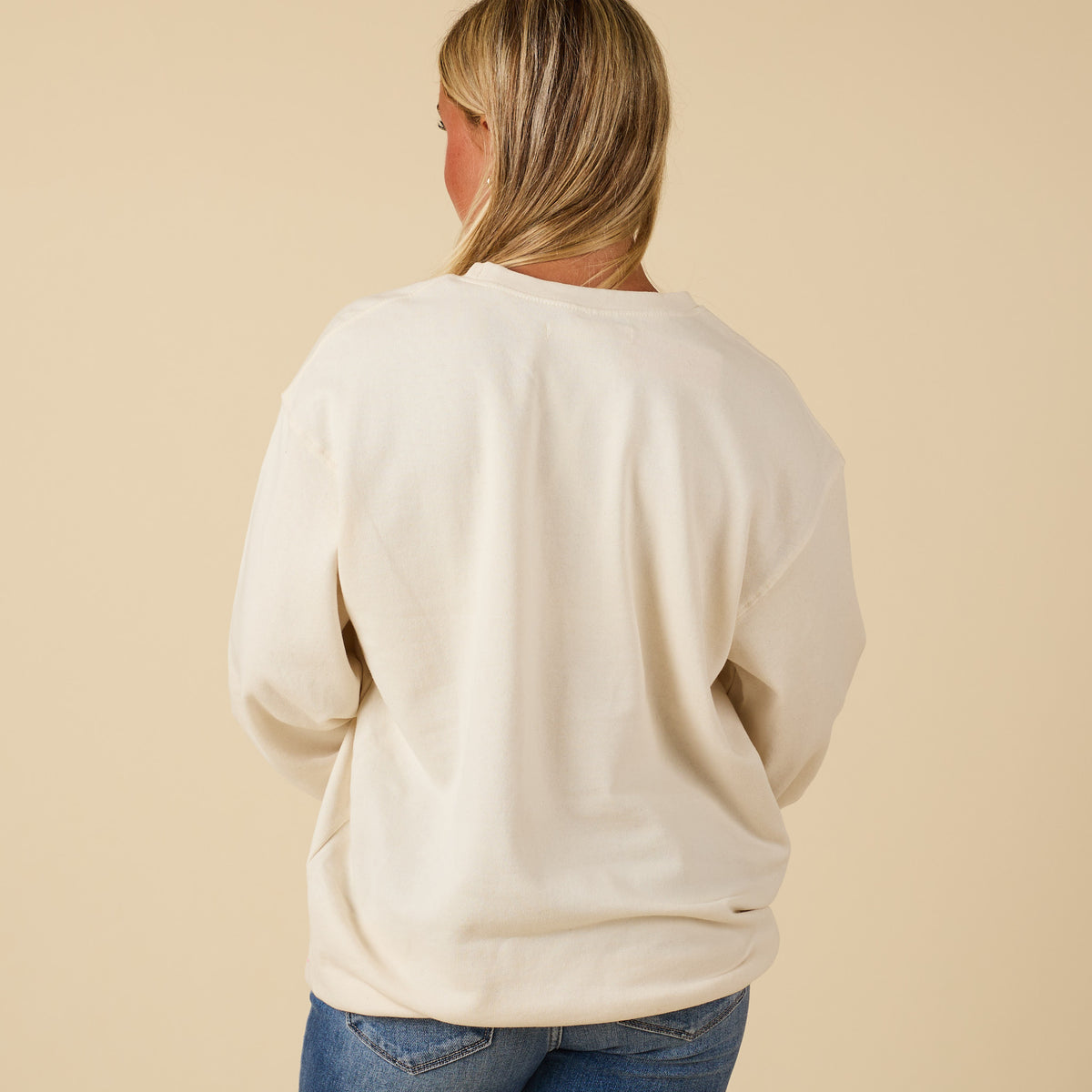 Sand crewneck sweatshirt shown from the back on model with no graphics visible.