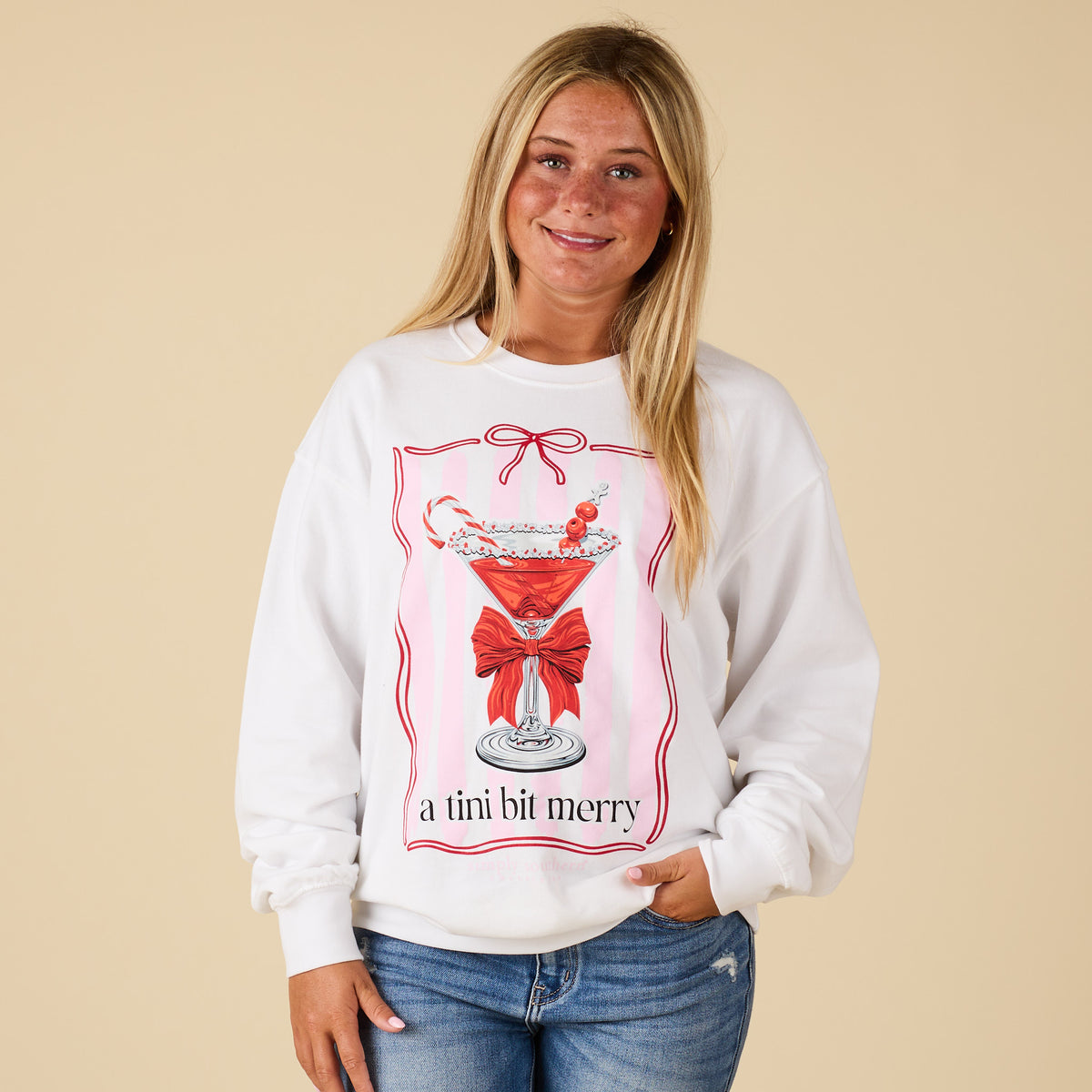 Front view of model wearing Simply Southern “A Tini Bit Merry” Sweatshirt in white with holiday martini glass graphic.