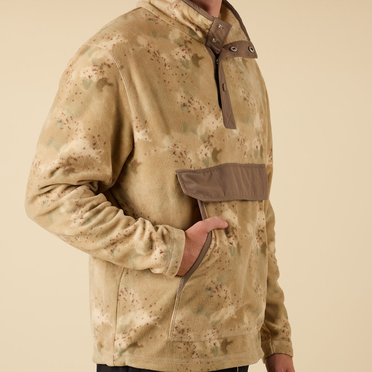 Camouflage jacket with a brown strap on a beige background