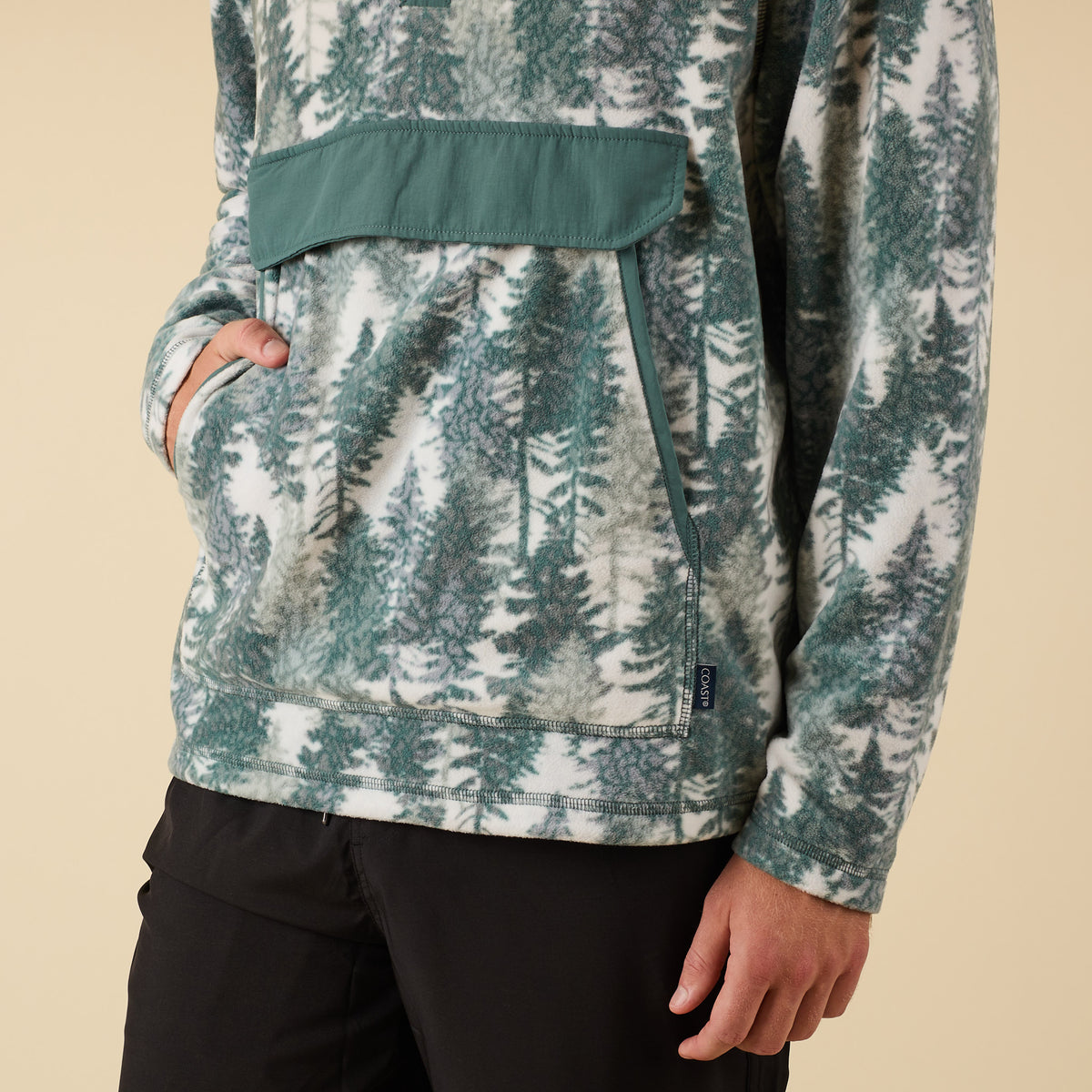 Close-up of front pocket and lower half of Crosby Fleece Quarter Snap Pullover showing tree print detail.
