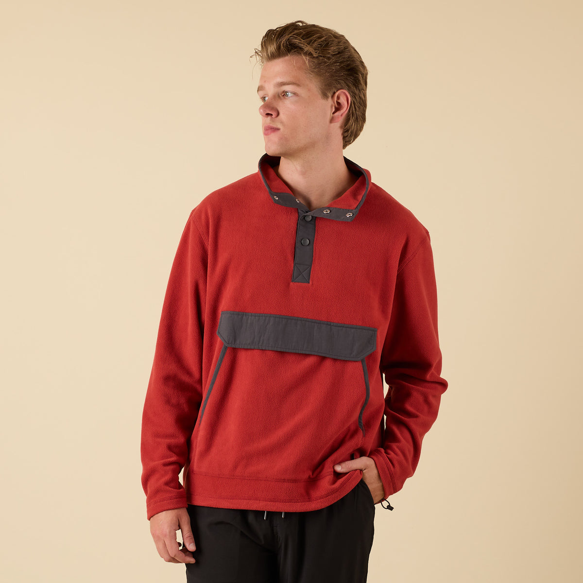 Front view of man wearing Crosby Fleece Quarter Snap Pullover in red with charcoal snap collar and front pocket.