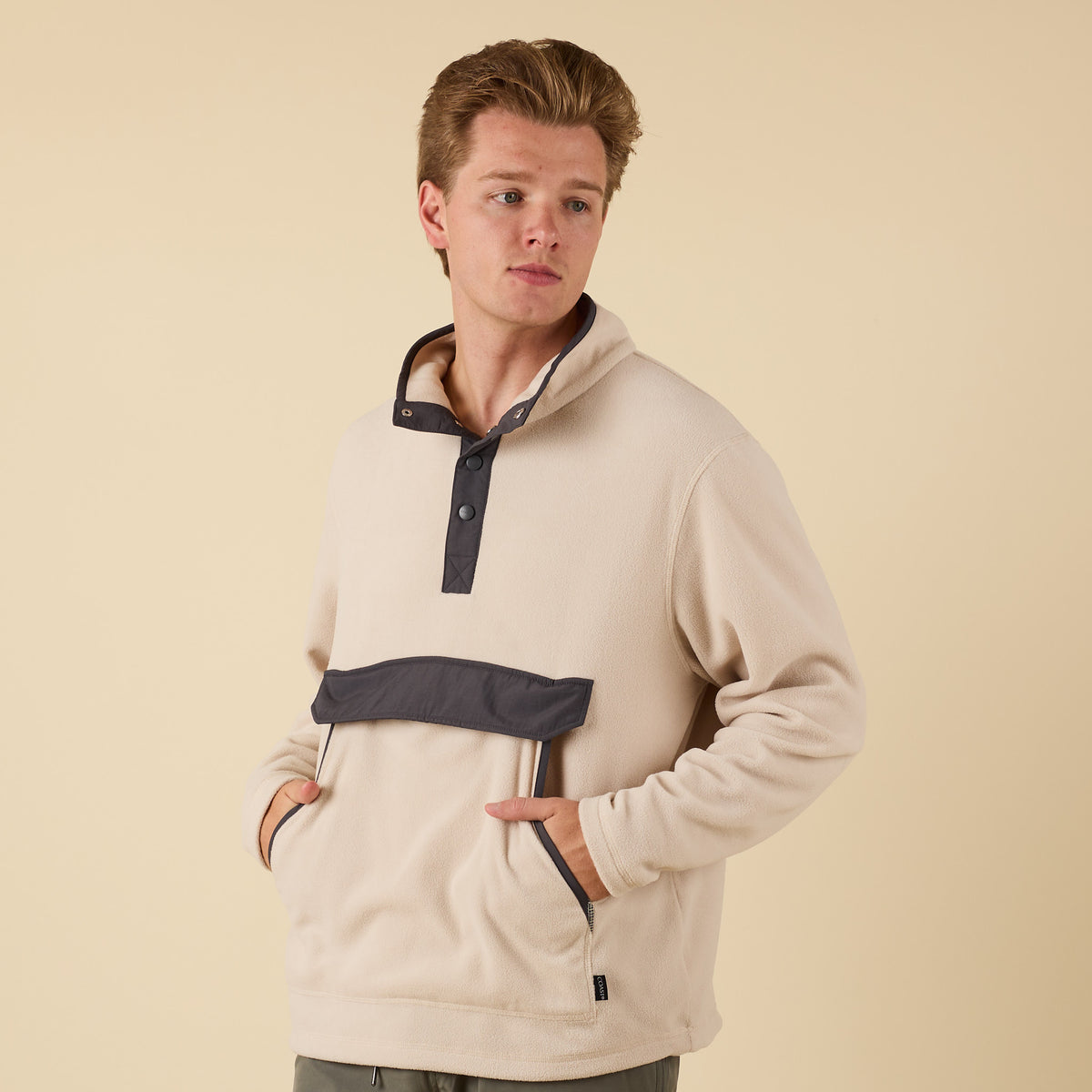 Front view of man wearing Crosby Fleece Quarter Snap Pullover in oatmeal with charcoal placket and flap pocket.