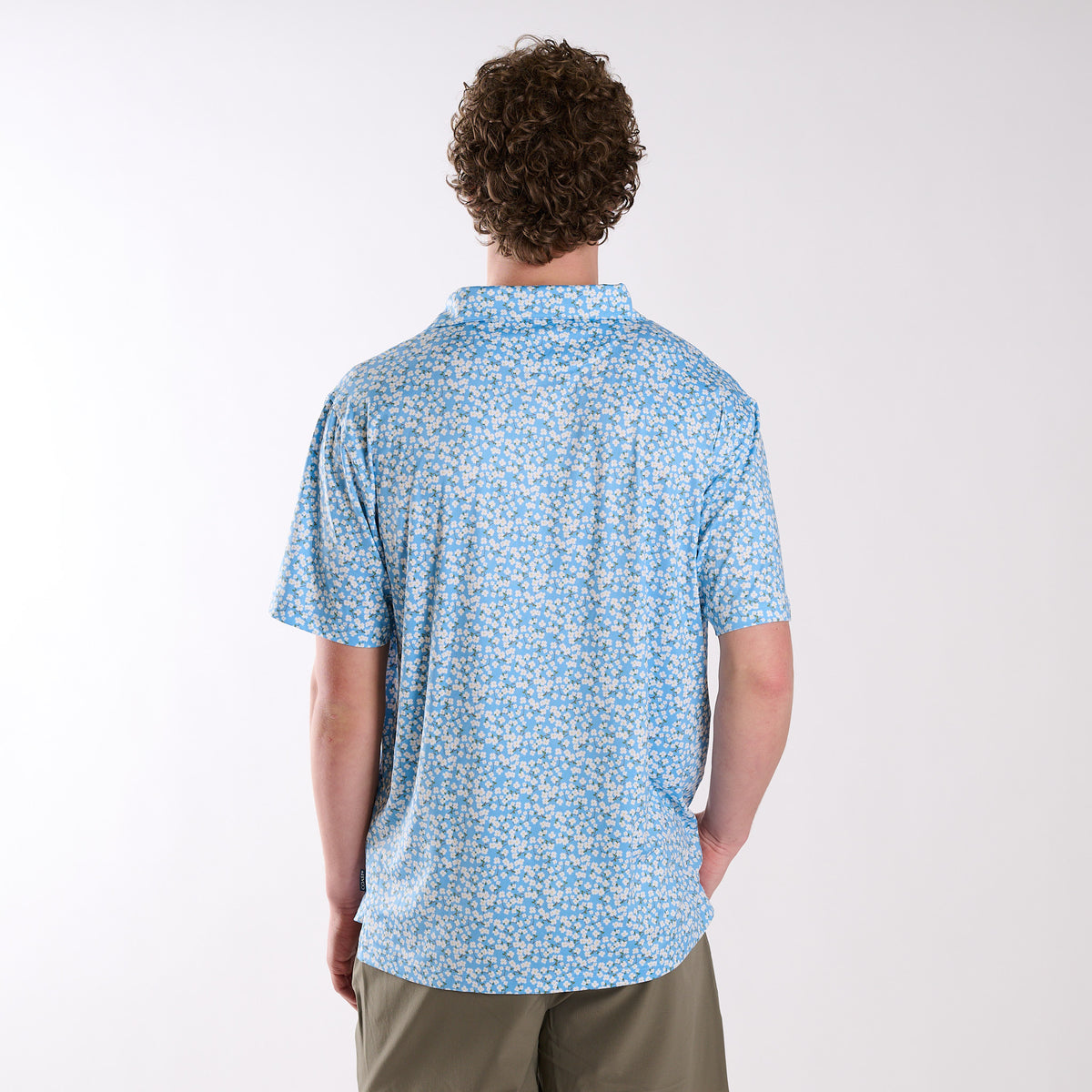 Person wearing a blue patterned shirt on a white background