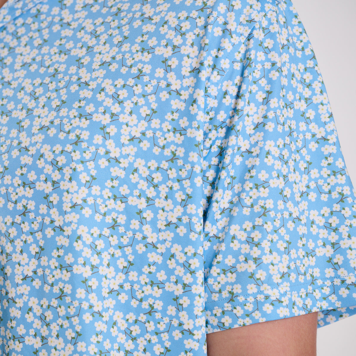Blue dress with white floral pattern on a plain background