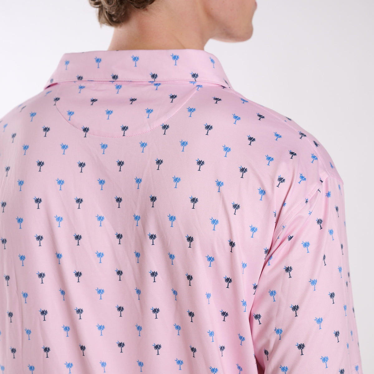 Back collar detail of COAST South Carolina Palm Tree Printed Polo in pink featuring the all-over palmetto tree print.