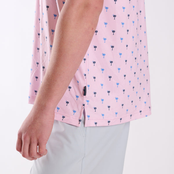 Close-up of COAST South Carolina Palm Tree Printed Polo in pink showing side hem vent and small palmetto tree pattern detail.