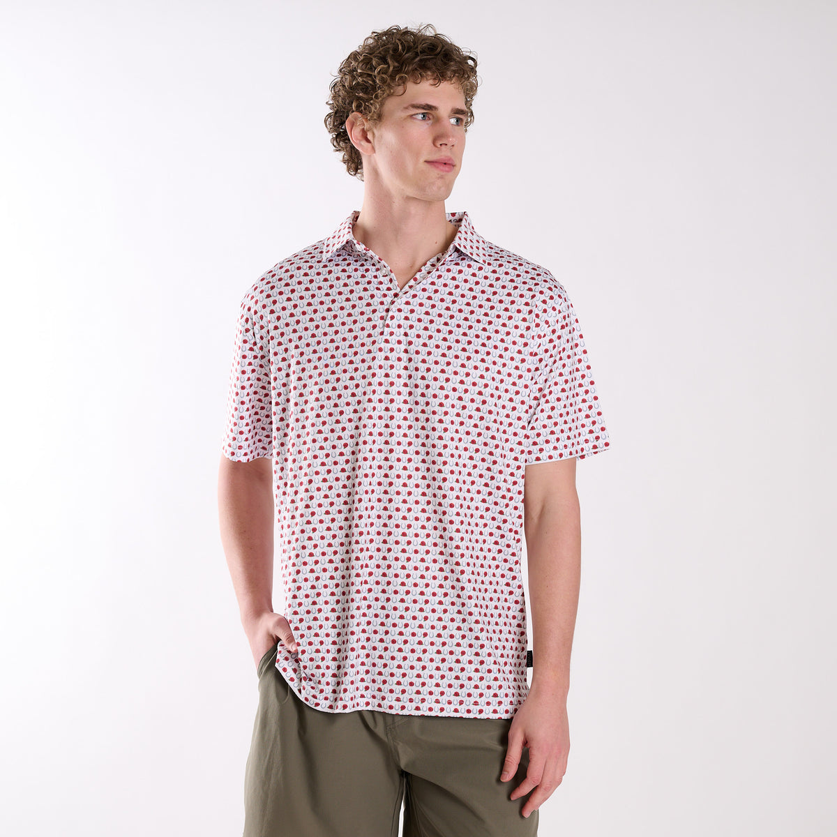Man wearing a patterned horseshoe and rose polo on a white background