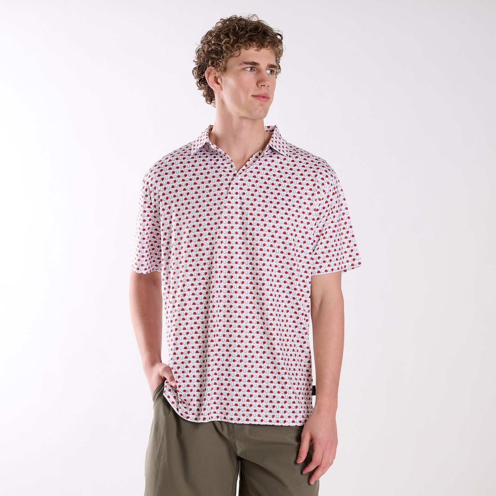 Man wearing a patterned horseshoe and rose polo on a white background