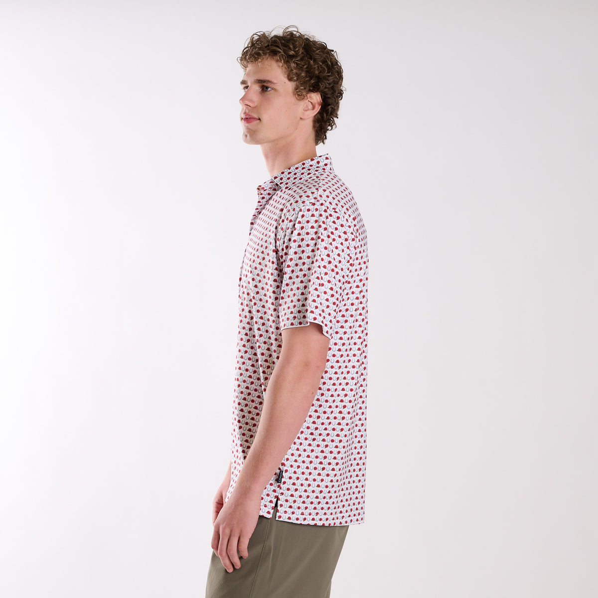 Man wearing a patterned horseshoe and rose polo on a white background
