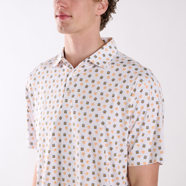 Close-up of COAST Tennessee Whiskey Tri Star Printed Polo in white showing the whiskey glass and orange tri-star pattern with classic collar and button placket.