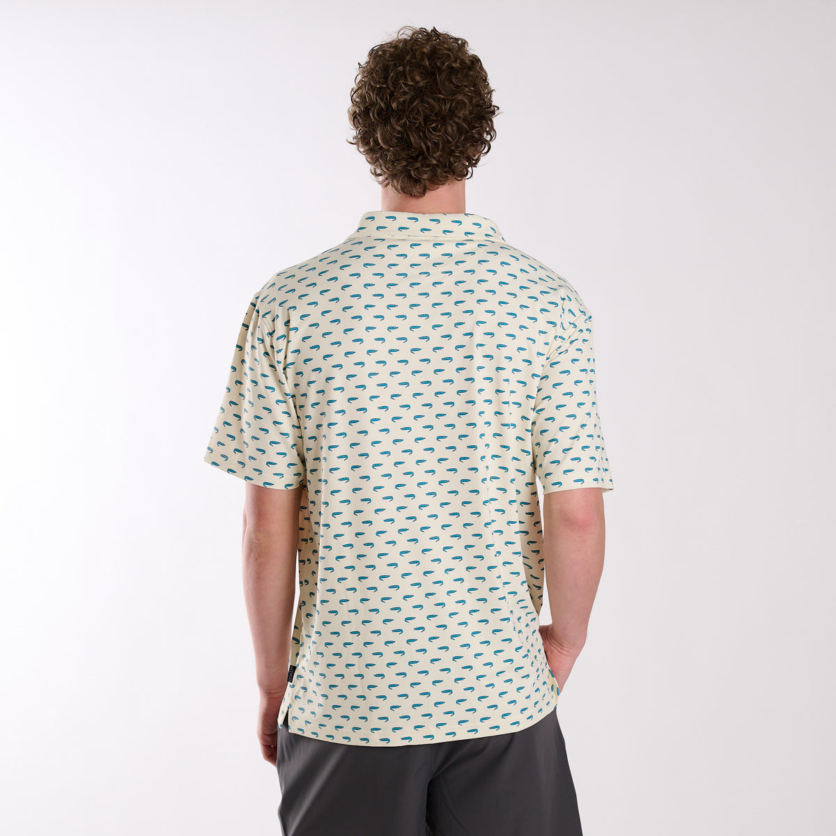 COAST Florida Gator Printed Polo in light yellow with small teal alligator print, shown from the back on a model in a studio setting.