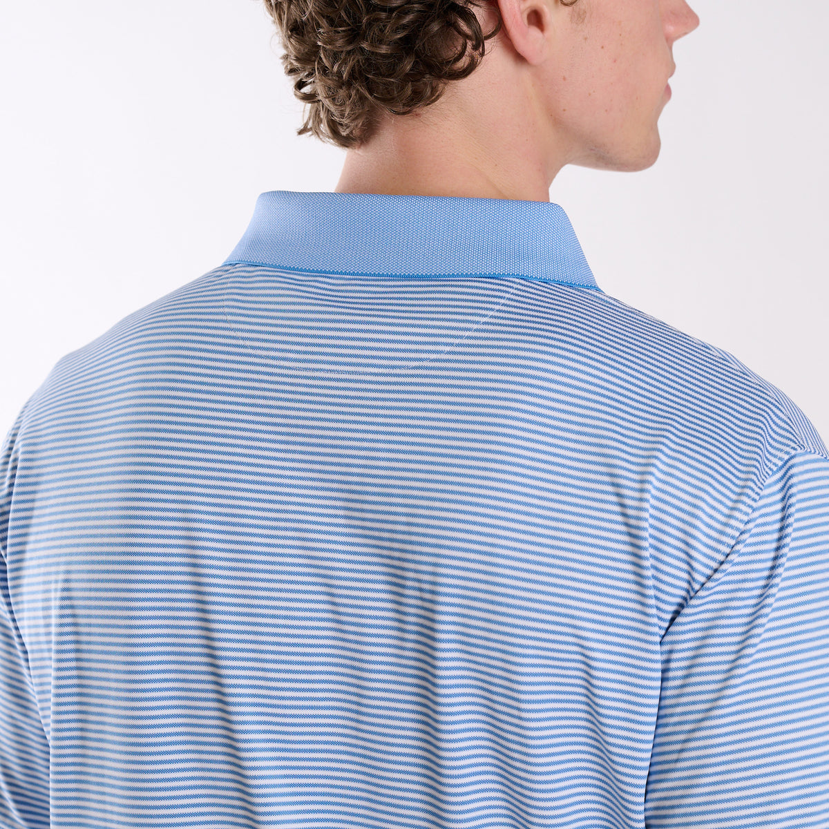Back shoulder detail of COAST Stripe Performance Polo highlighting the micro-stripe pattern and structured collar.