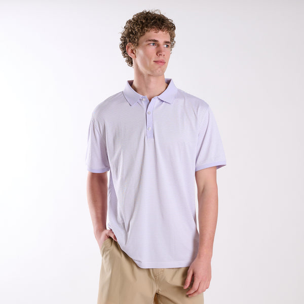 COAST micro-stripe performance polo in light lavender with white stripes, shown on a model wearing khaki shorts against a neutral studio background.