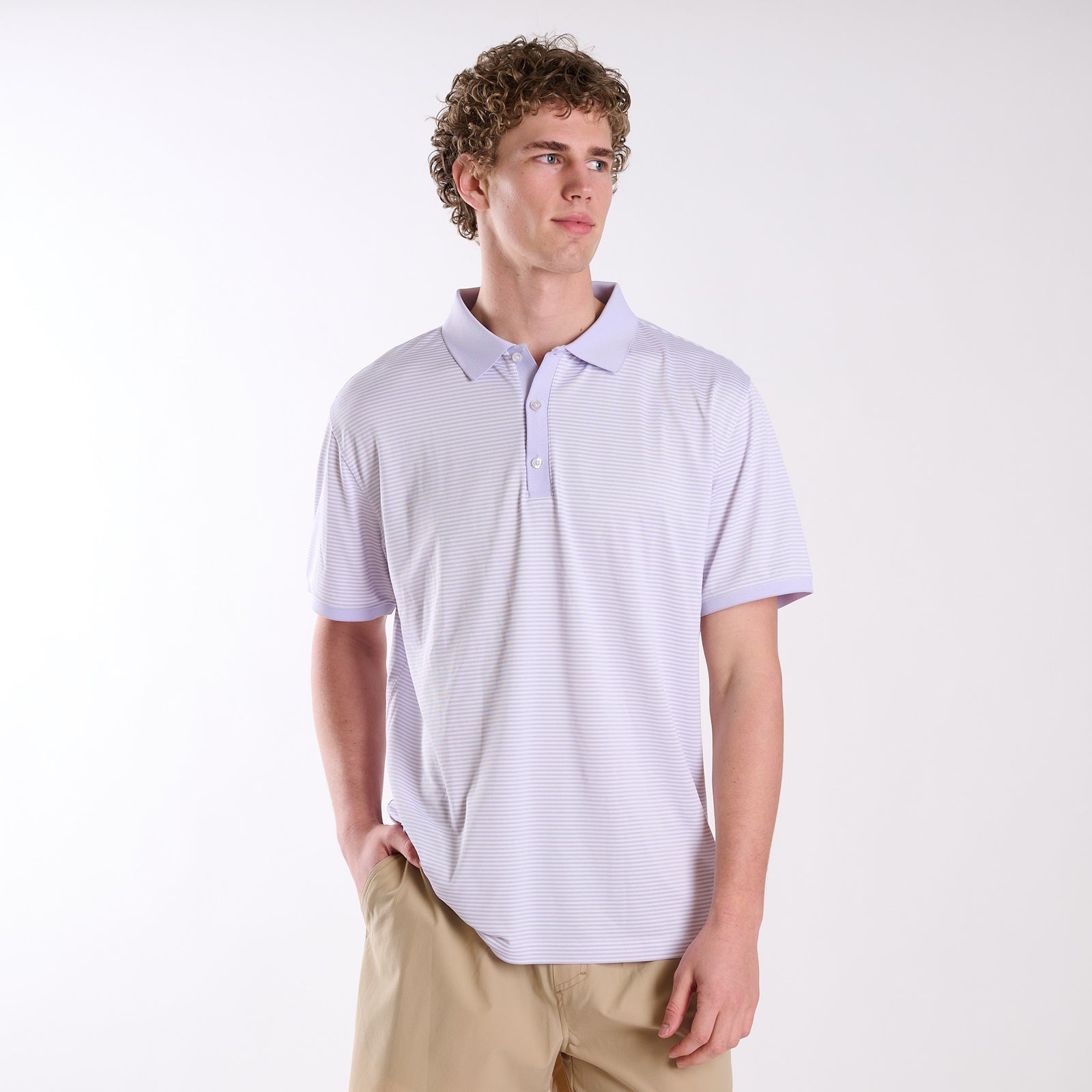 COAST micro-stripe performance polo in light lavender with white stripes, shown on a model wearing khaki shorts against a neutral studio background.