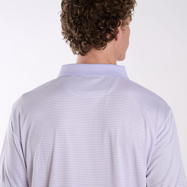 Back view of COAST micro-stripe performance polo in light lavender with white stripes, worn by a model in a studio setting.