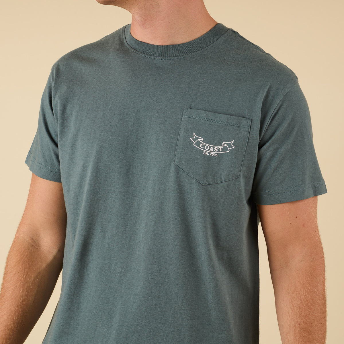 Front view of COAST Cross Clubs Tee showing chest pocket with small COAST logo banner and "Est. 2006" text.