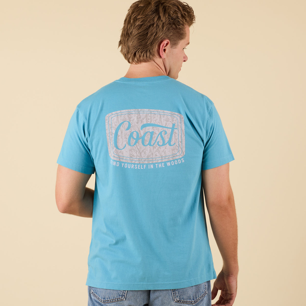 COAST Camo Label short sleeve t-shirt in aqua blue with back graphic featuring camo label and text "Find Yourself in the Woods."