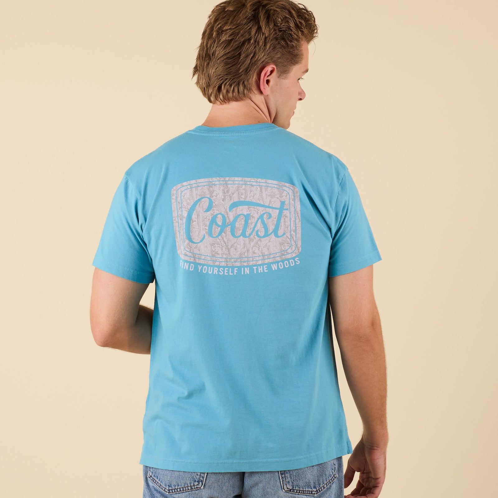 COAST Camo Label short sleeve t-shirt in aqua blue with back graphic featuring camo label and text "Find Yourself in the Woods."