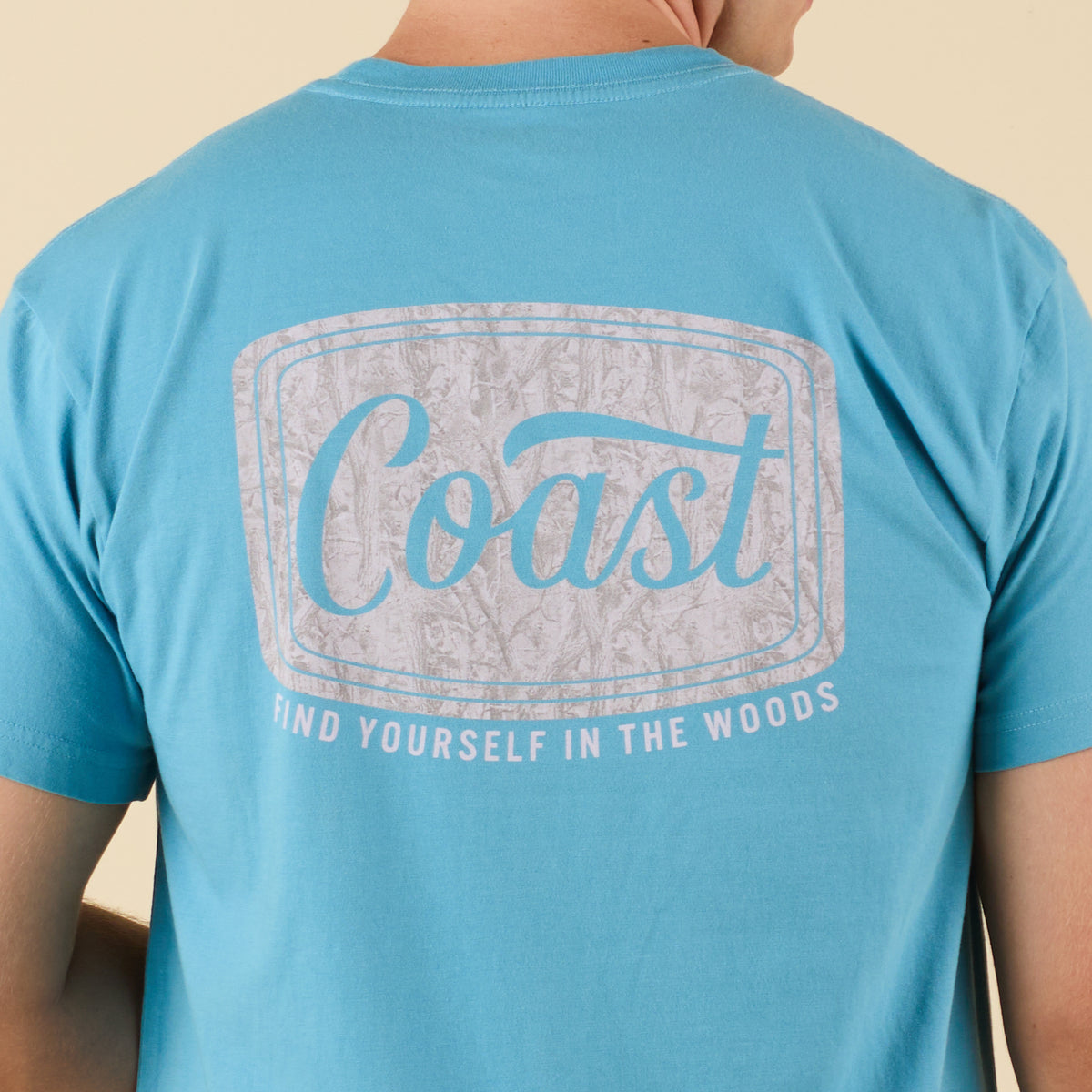 Blue t-shirt with 'Coast' and 'Find Yourself in the Woods' text on the back.