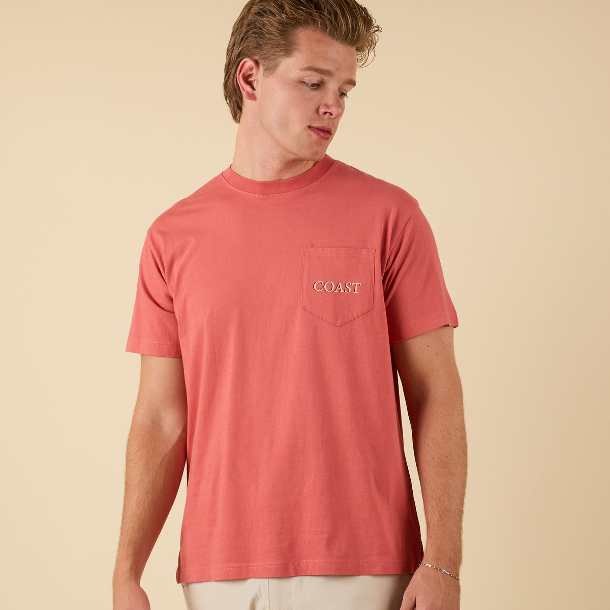 Front view of COAST Always On Point tee in red with COAST logo on chest pocket.