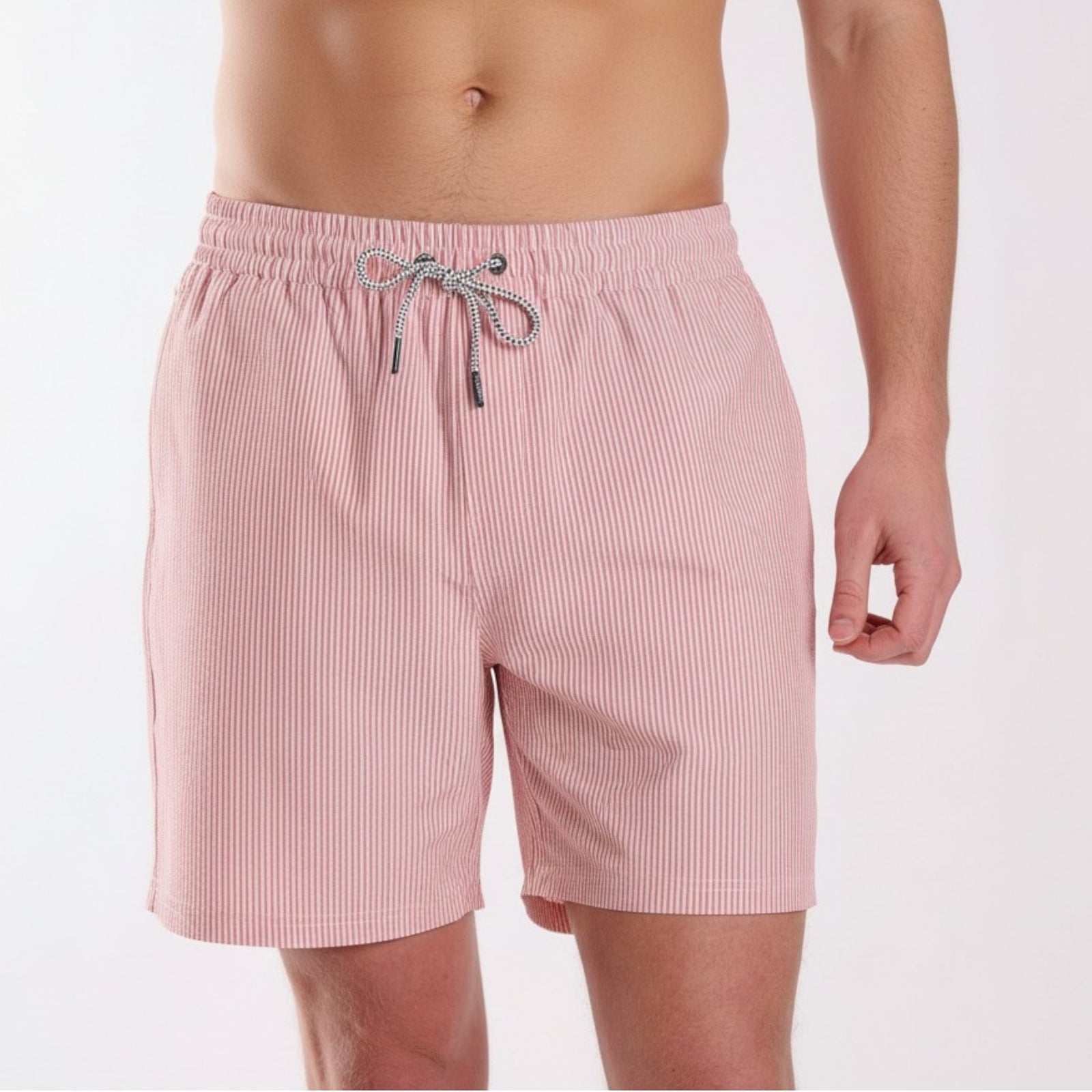 Pink striped swim shorts worn by a person on a white background