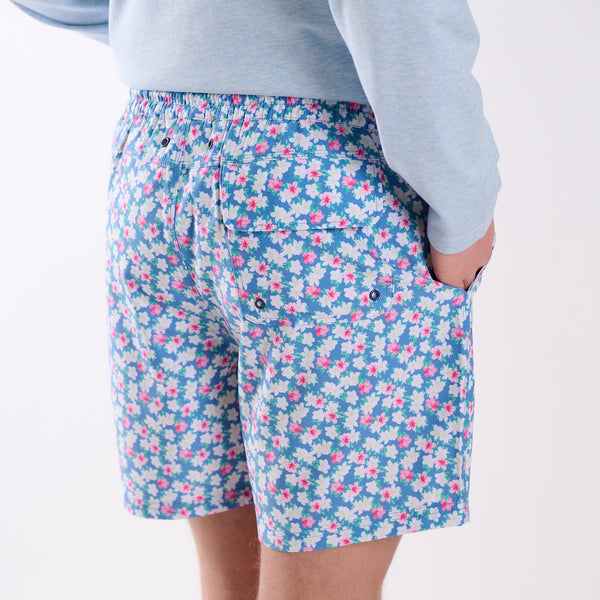 Back view of COAST azalea printed volley swim shorts featuring blue floral print and rear flap pocket with drainage grommets.