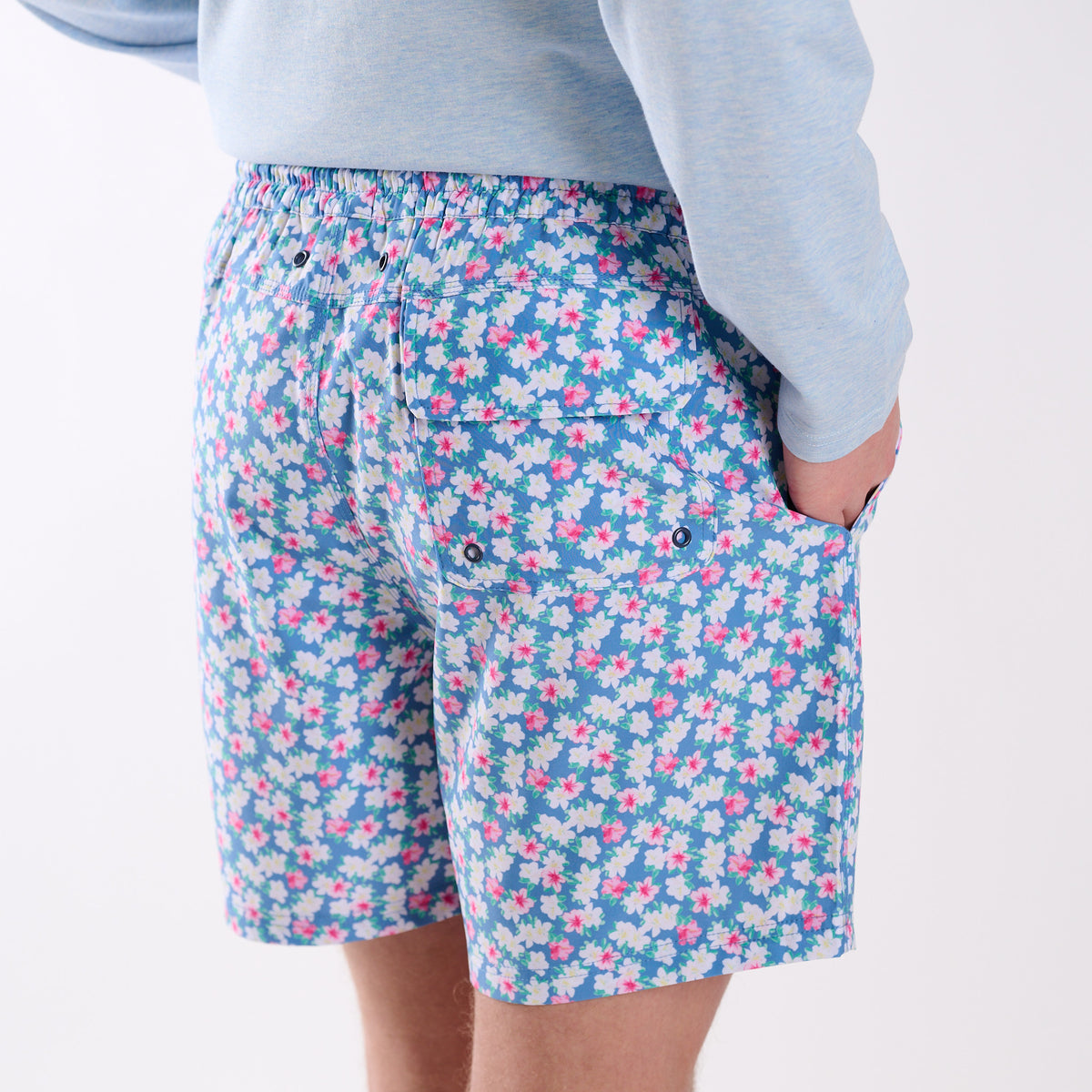Back view of COAST azalea printed volley swim shorts featuring blue floral print and rear flap pocket with drainage grommets.