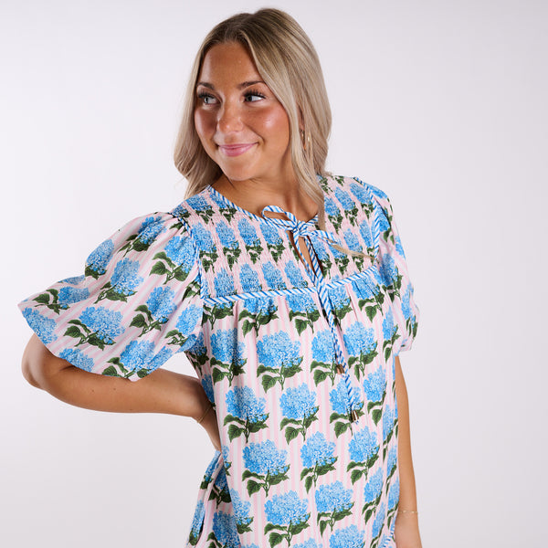 Woman wearing a floral dress with blue flowers on a white background
