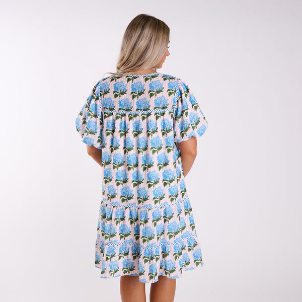 Woman wearing a floral dress with blue flowers on a white background