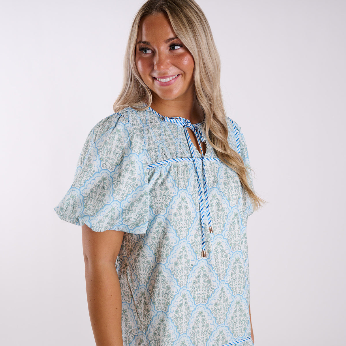 Woman wearing a floral patterned dress with a white background