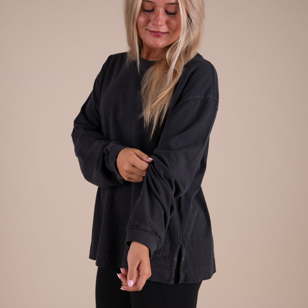 Woman wearing a black oversized t-shirt against a beige background