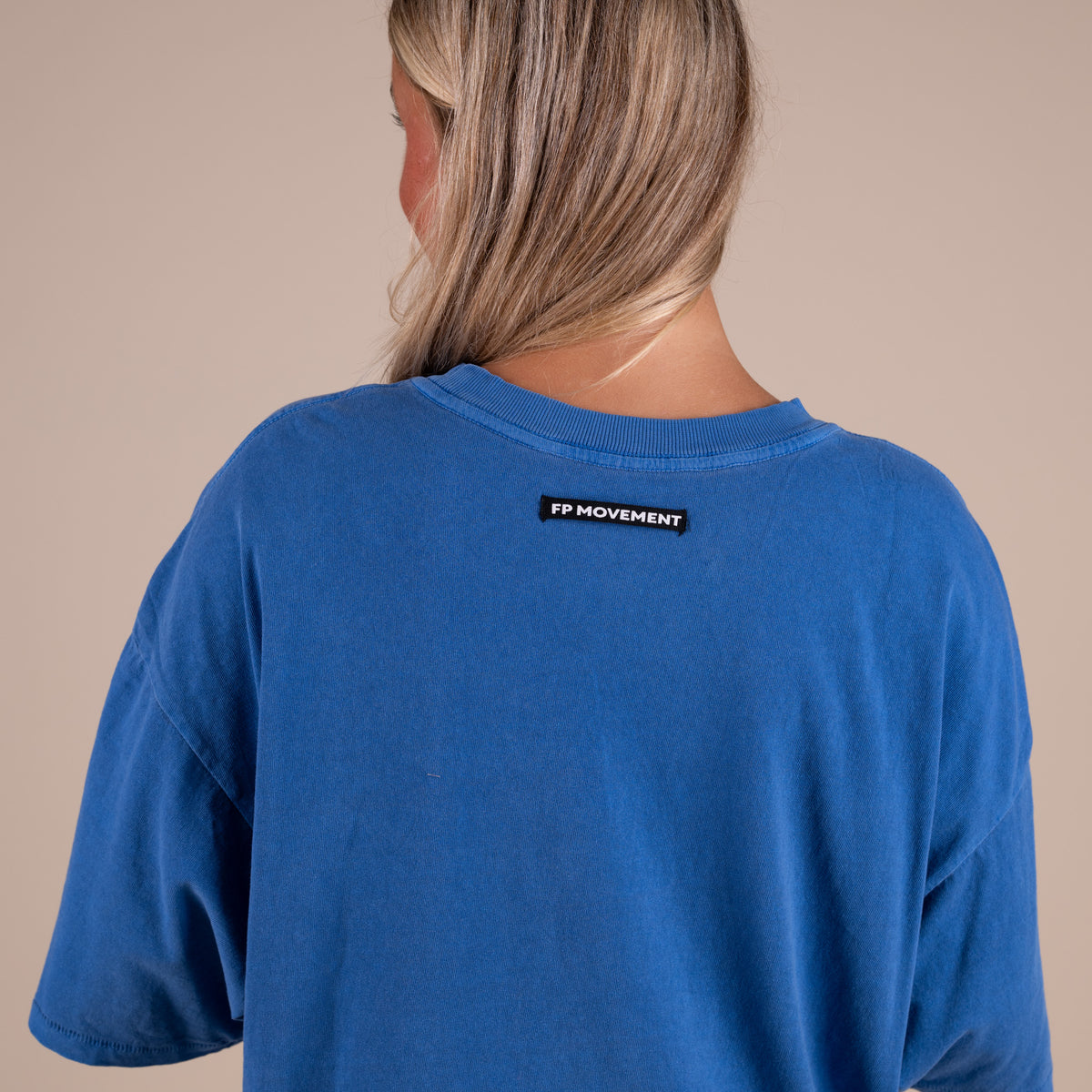 Woman wearing FP Movement Tackle Tee in Light Cobalt Blue